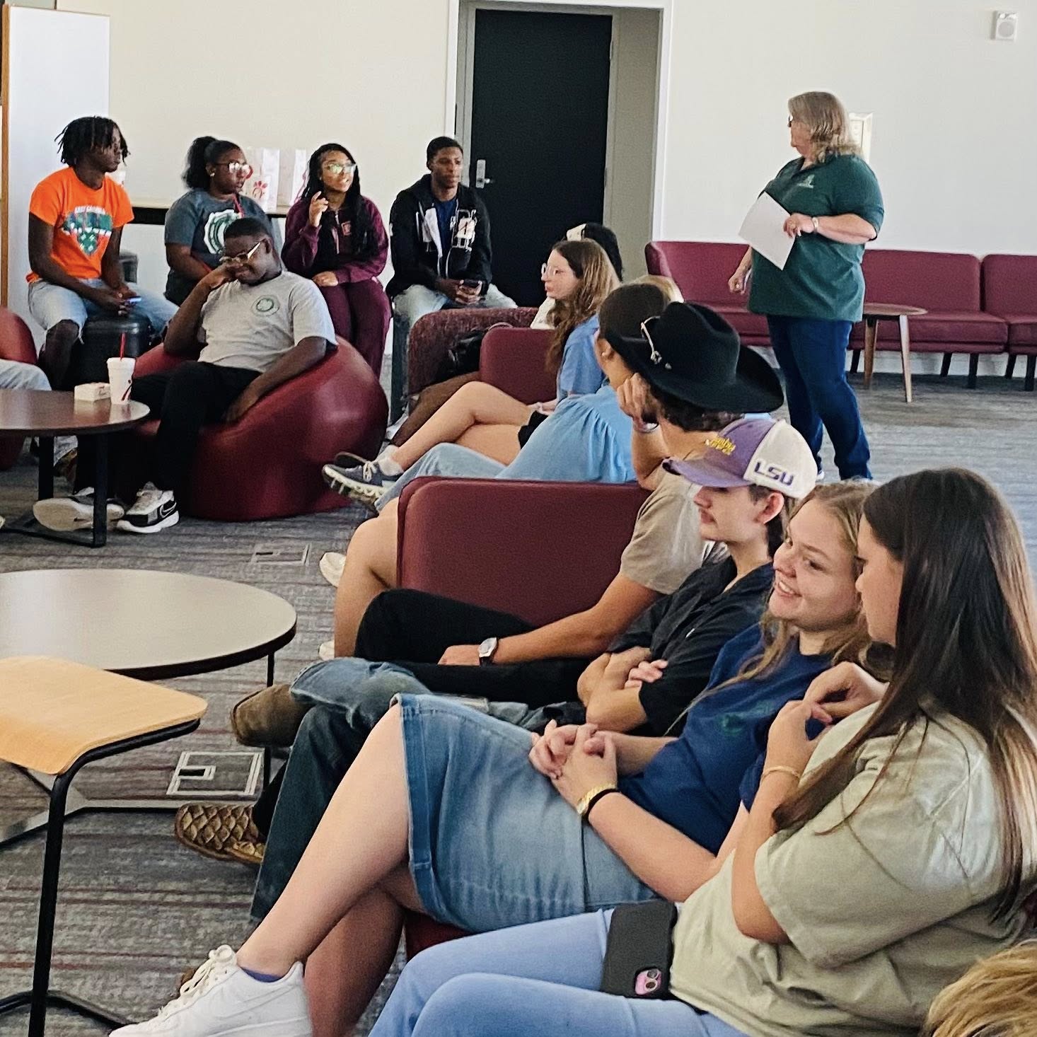 A bunch of teenagers sitting in a room.
